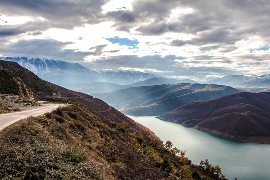 A lake between mountains under a cloudy sky